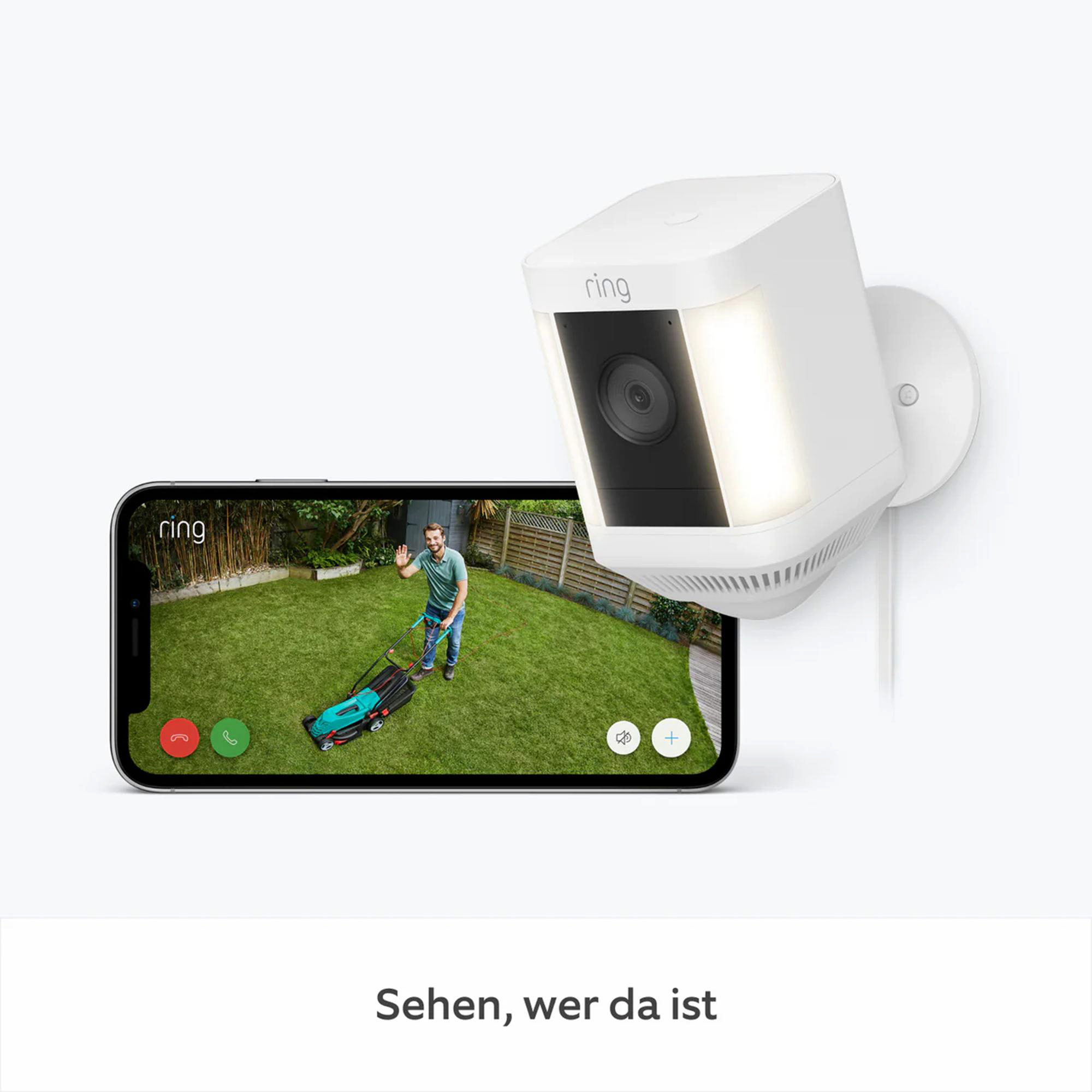Eine Ring-Sicherheitskamera mit einem Telefon, das einen Mann beim Rasenmähen zeigt. Die Kamera ist weiß, das Telefon zeigt die Ansicht.