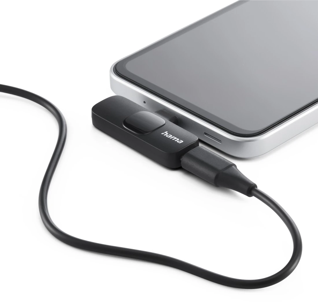 Un appareil Hama noir connecté à un smartphone avec un câble noir. Fond blanc.