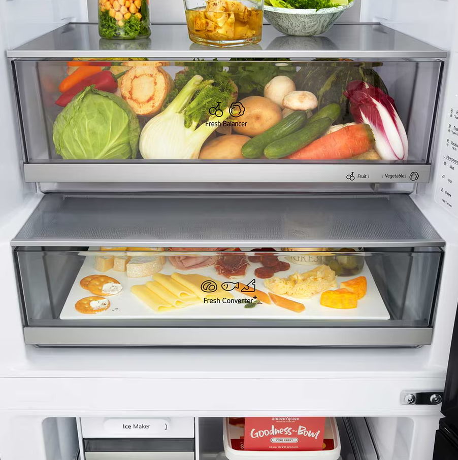 In einem Kühlschrank befinden sich Schubladen mit Gemüse, Obst und Fertiggerichten. Dazu gehören Kohl, Karotten, Käse und eine „Goodness-Bowl“.