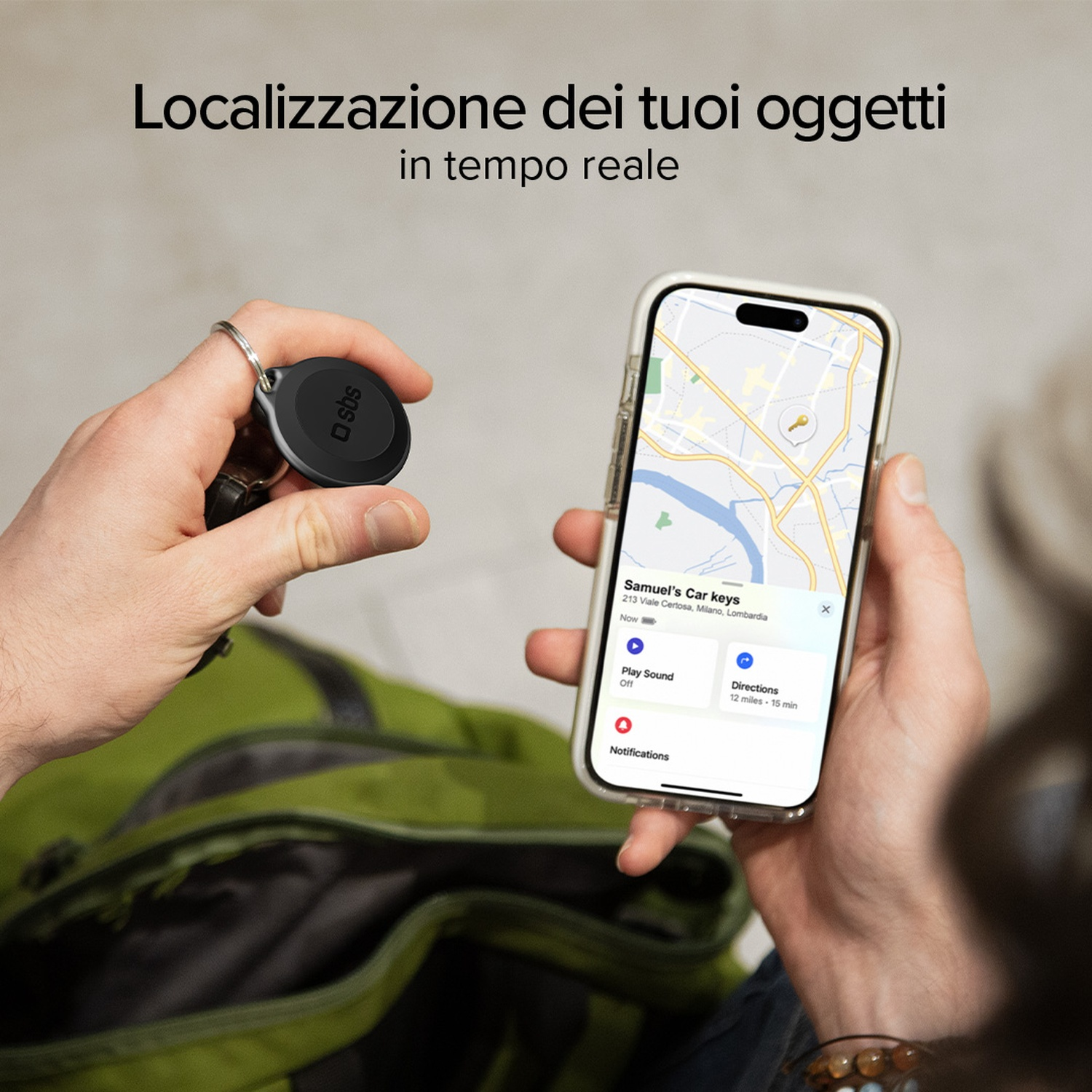 Una persona tiene in mano un localizzatore e un telefono che mostra una mappa. Il telefono mostra la posizione delle chiavi dell'auto.
