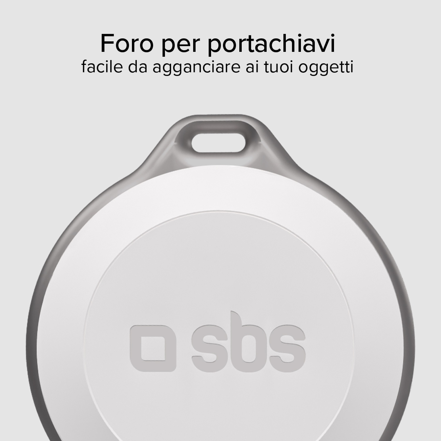 Un tag circolare bianco con un foro, il logo 'sbs' è visibile. Testo in alto: 'Foro per portachiavi facile da agganciare ai tuoi oggetti'.