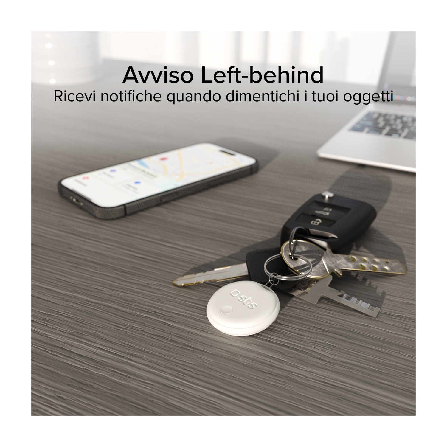 Chiavi, telefono e tracker bianco su tavolo grigio. Il telefono mostra una mappa. Testo: Dimenticato. Ricevi notifiche quando dimentichi i tuoi oggetti.