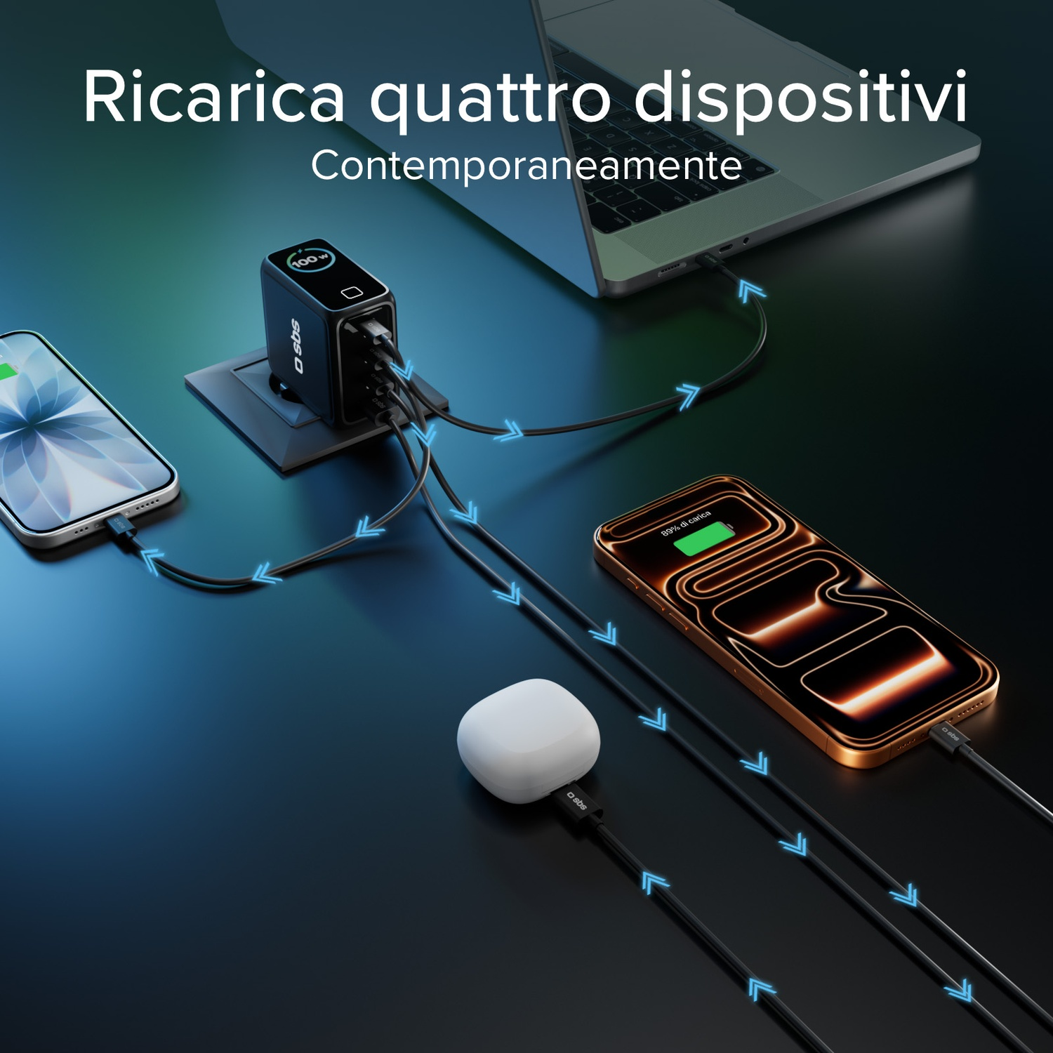 Un caricabatterie nero con quattro porte sta caricando quattro dispositivi: un telefono, un laptop, un telefono e auricolari, il tutto su una superficie scura.