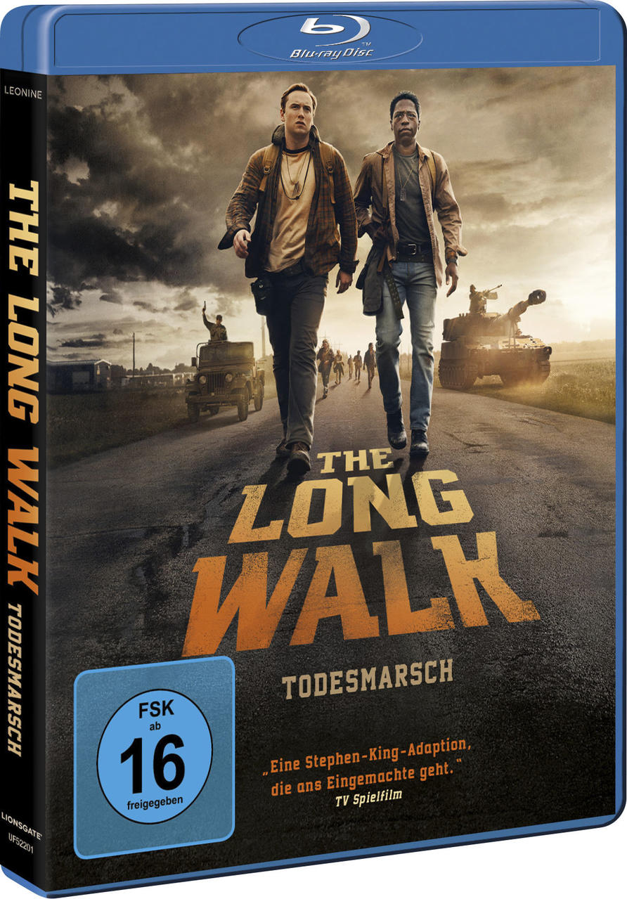 Blu-ray-Cover: Zwei Männer gehen auf einer Straße. Militärfahrzeuge und eine Menschenmenge sind im Hintergrund. Der Titel lautet 'The Long Walk'.