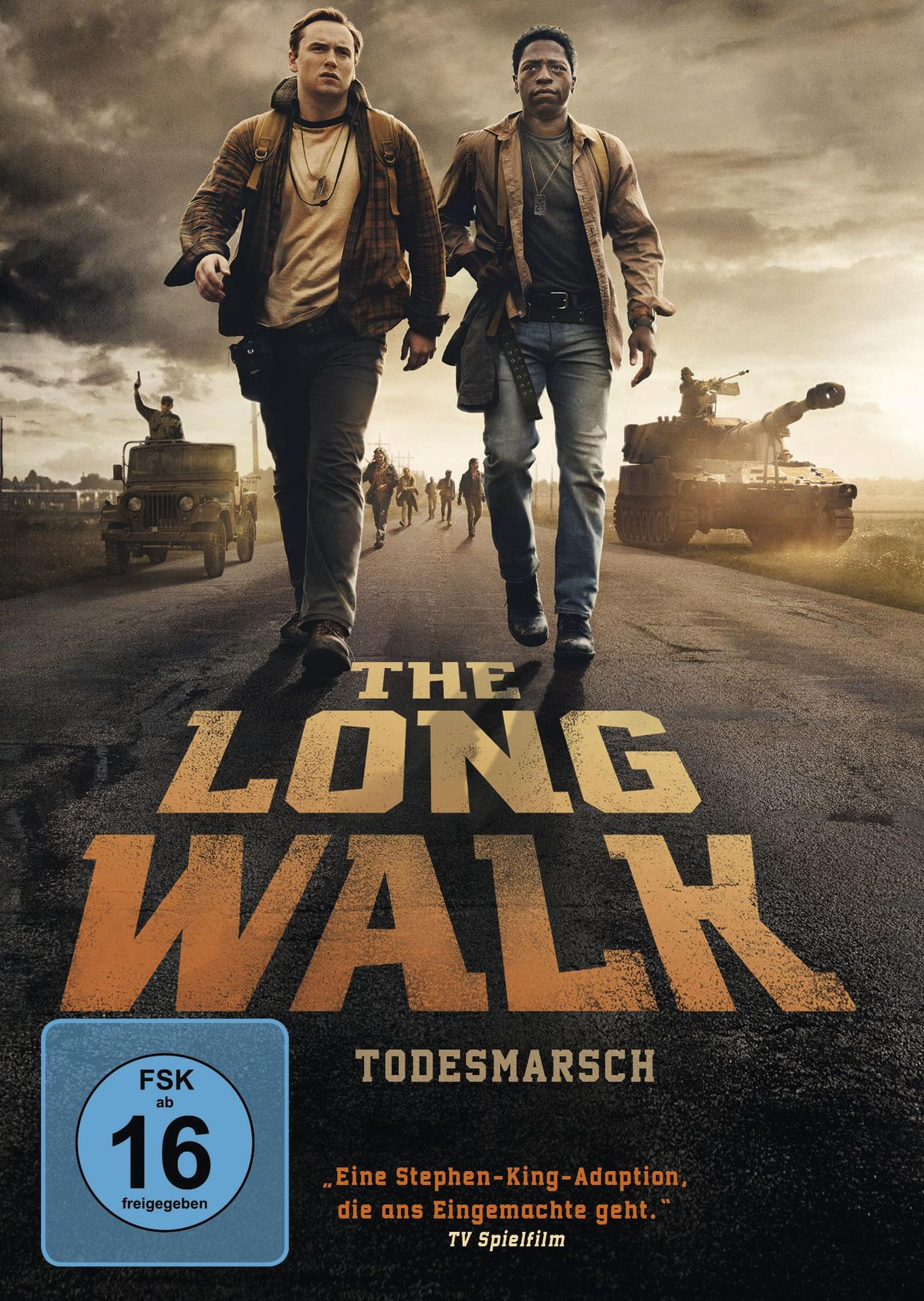 Zwei Männer gehen auf einer Straße, Filmplakat für "The Long Walk". Ein Panzer, Soldaten und ein Jeep sind im Hintergrund zu sehen.