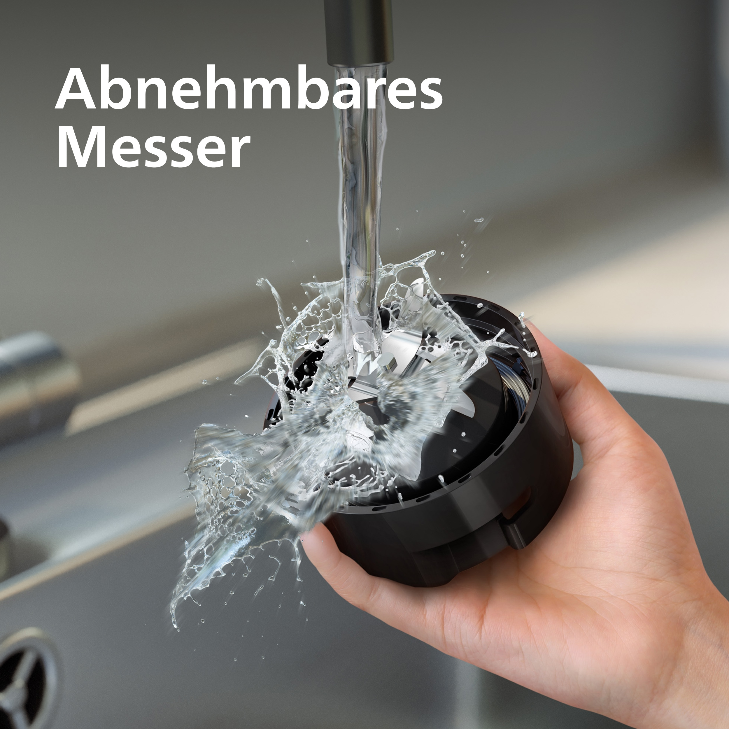 Eine Hand hält einen schwarzen Mixeraufsatz unter fließendem Wasser. Wasser spritzt um den Aufsatz herum.