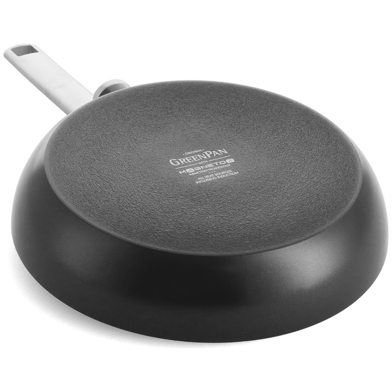 A black GreenPan frying pan, bottom view. It has a white handle and a textured gray cooking surface. The pan is on a white surface.