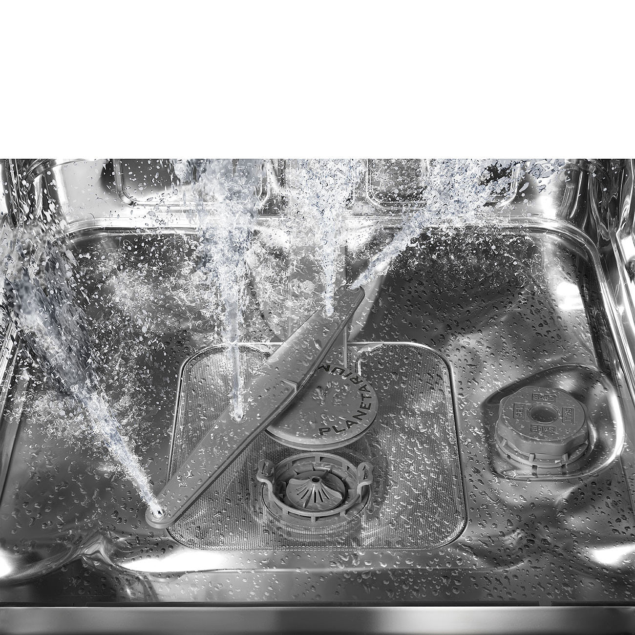 In einem Geschirrspüler spritzt Wasser aus einem rotierenden Arm und trifft auf das Edelstahl-Innere. Wassertropfen bedecken die Oberflächen.