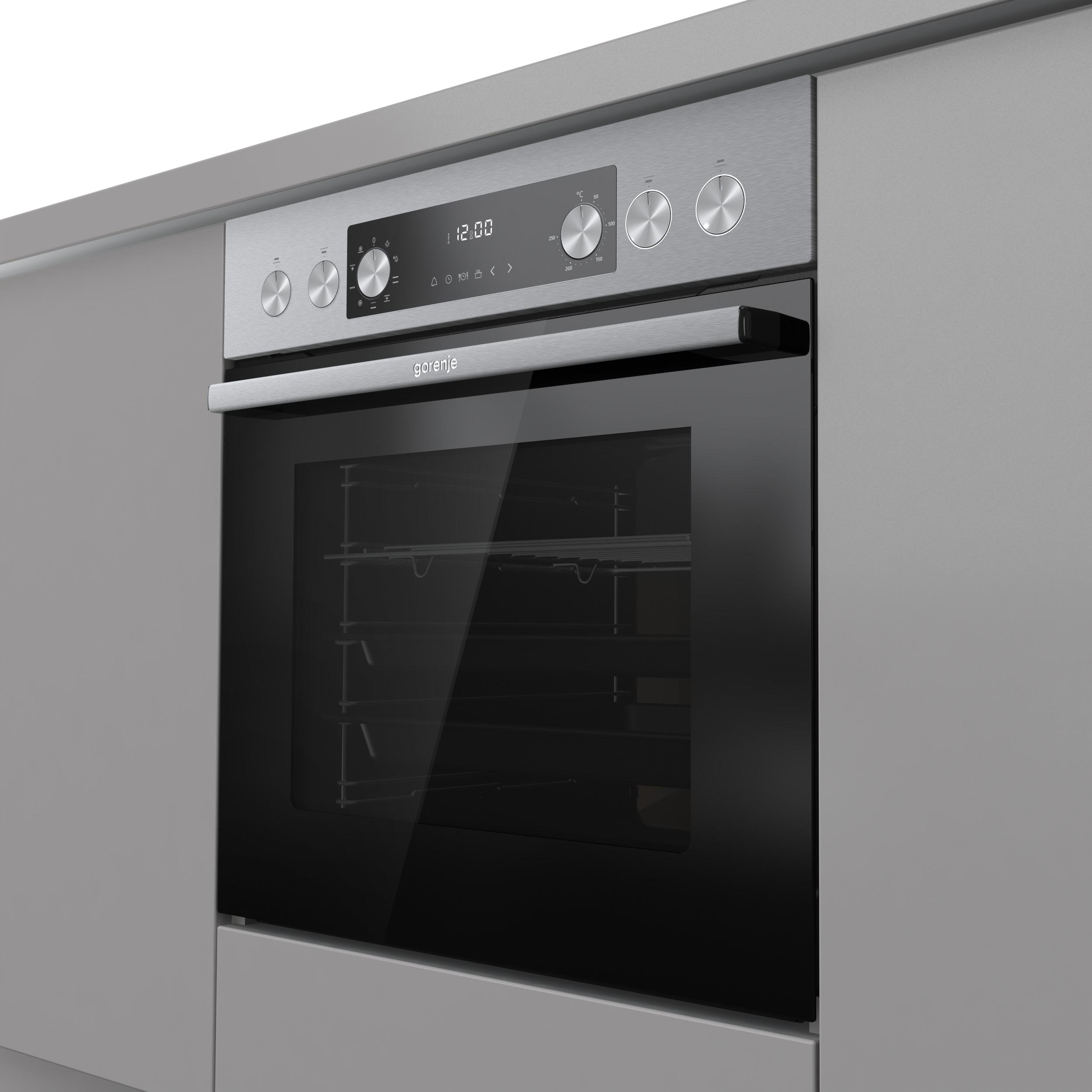 Ein Edelstahlbackofen ist in einen grauen Schrank eingebaut. Er hat eine schwarze Glastür und eine Digitalanzeige mit Knöpfen.
