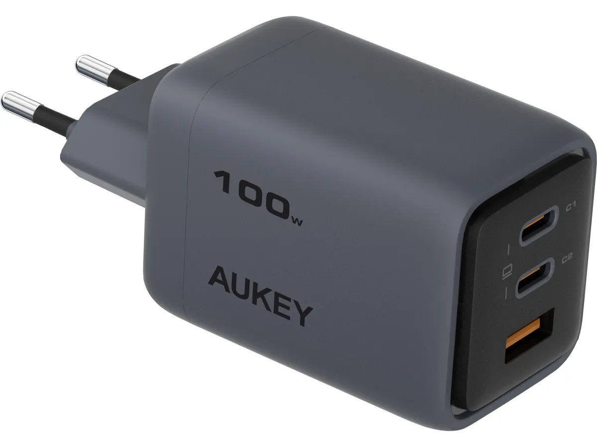 Un caricatore AUKEY grigio da 100W con due porte USB-C e una porta USB-A. Ha una spina a due poli.