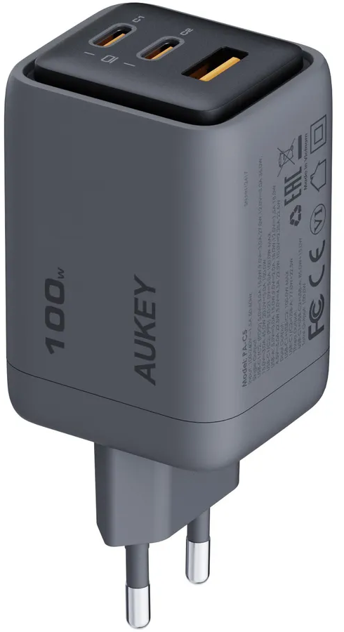 Un caricabatterie USB AUKEY grigio da 100 W con due porte USB-C in alto. Ha una spina europea e dettagli del prodotto.