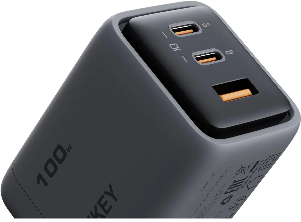 Un power bank nero e grigio con più porte, tra cui USB-C e USB-A, e un'etichetta da 100W.