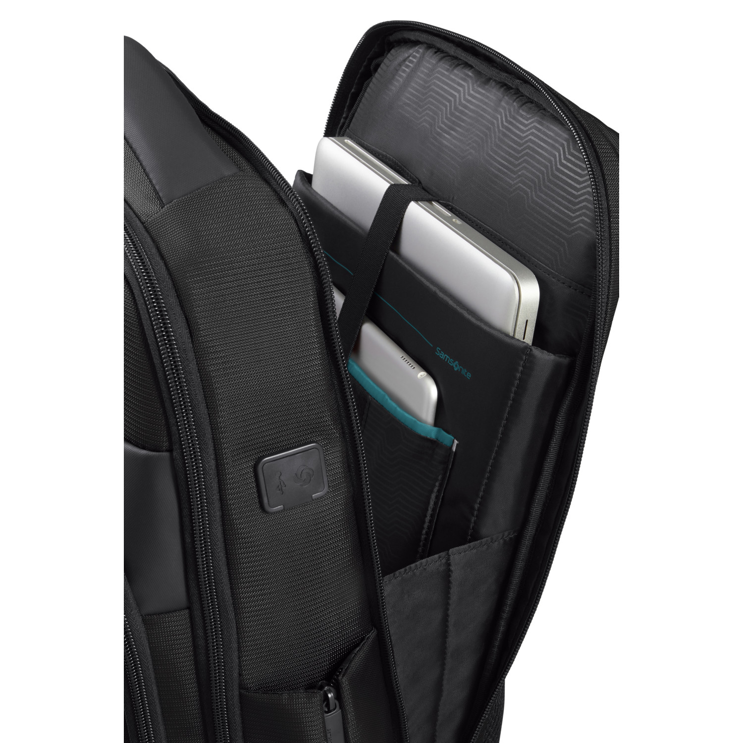 Siyah Samsonite sırt çantası açık, elektronik cihazların bulunduğu bölmeleri gösteriyor. Dizüstü bilgisayarlar ve telefonlar görünüyor. İç kısım siyah.