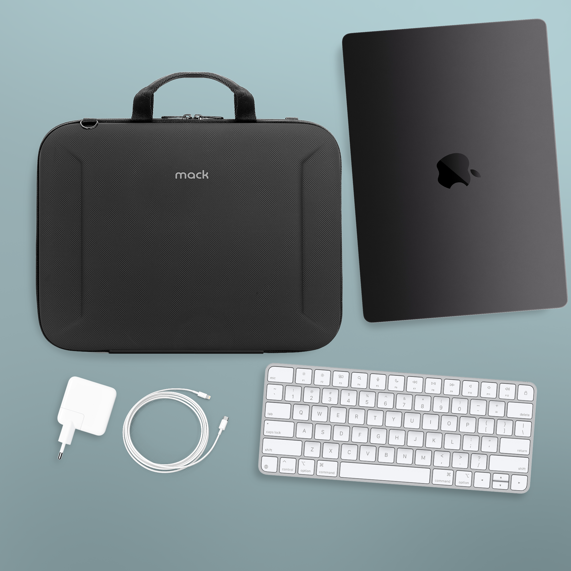 Siyah dizüstü bilgisayar, çanta, klavye, şarj aleti ve kablo mavi-gri yüzeyde. Apple logosu görünür.
