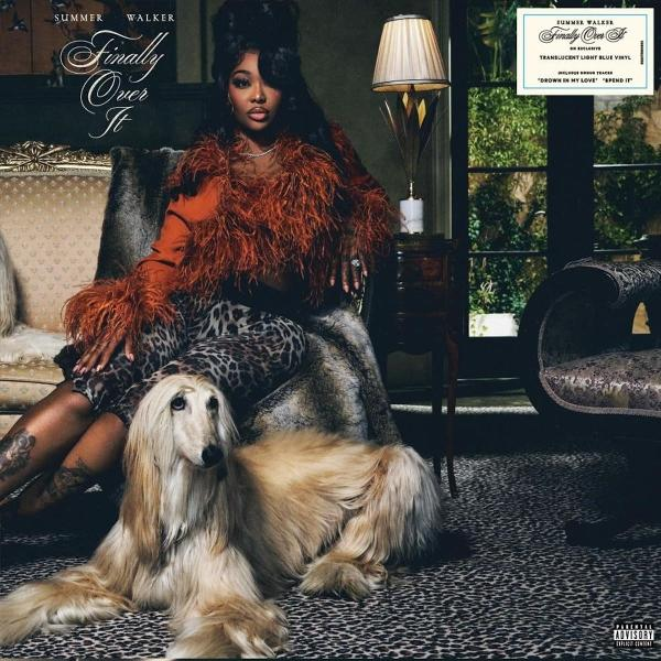 Summer Walker sitzt auf einer Couch, trägt Orange und Leopardenmuster. Ein Hund liegt auf dem Boden. Albumcover im Hintergrund.
