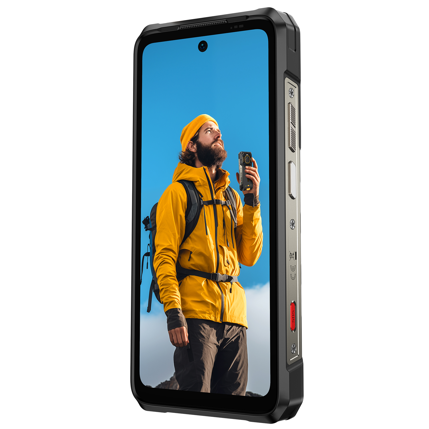Egy telefon sárga kabátos és sapkás férfit mutat, aki kamerát tart, a kék eget nézi, egy hegyen áll.