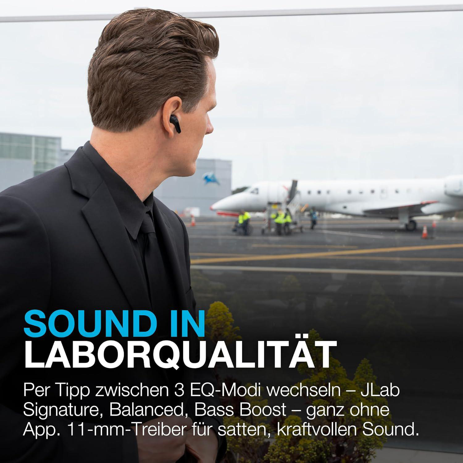 Ein Mann im Anzug blickt auf ein Flugzeug. Er trägt Ohrhörer. Text: SOUND IN LABORQUALITÄT.