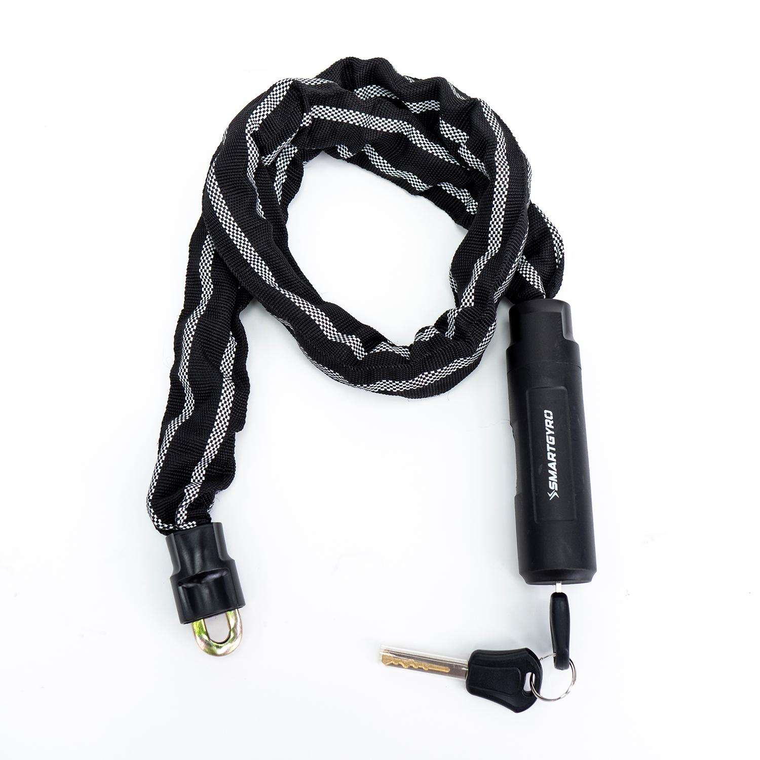 Candado de cadena blanco y negro con llave y cilindro de cerradura, sobre una superficie blanca. La marca es SMARTGYRO.