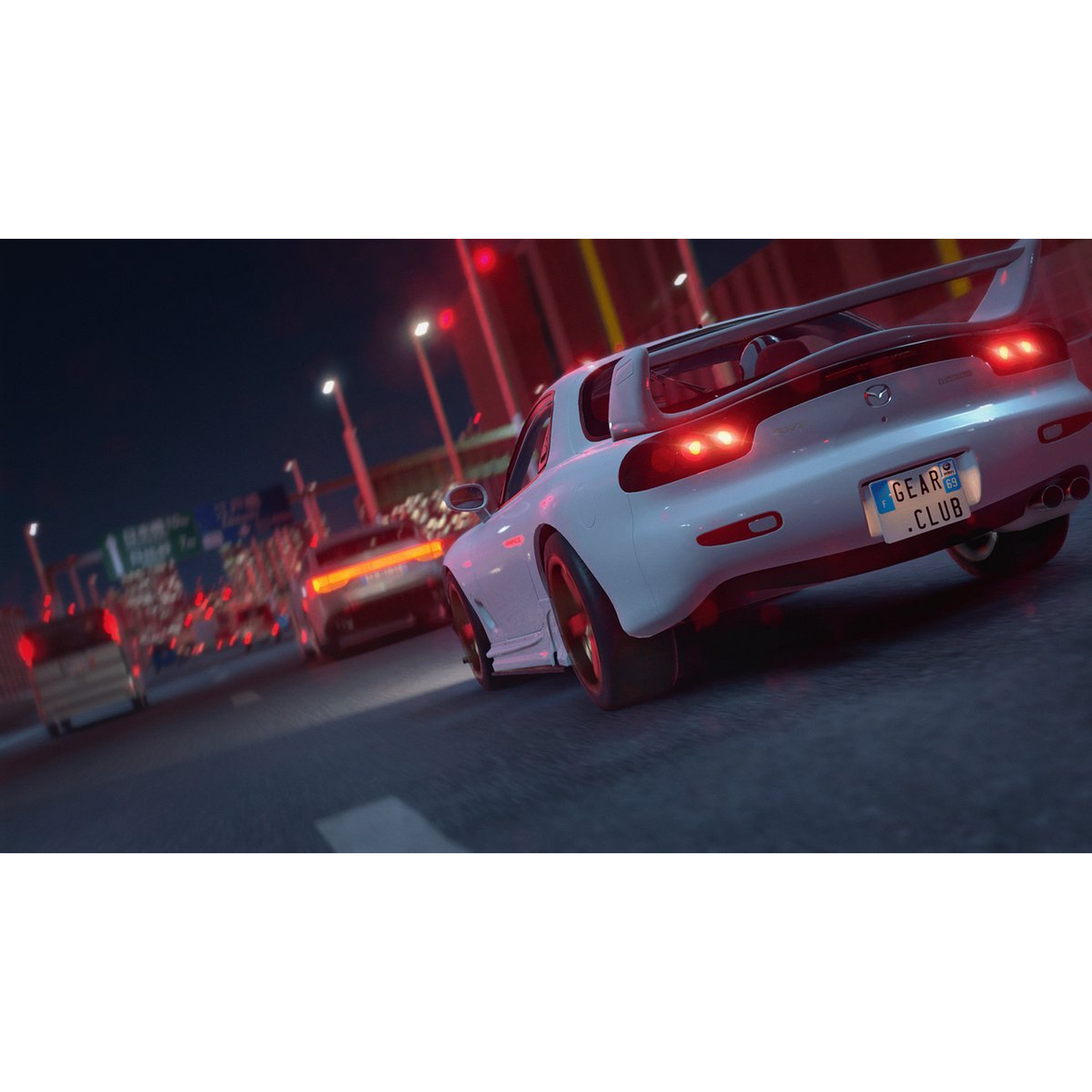 A white sports car with a spoiler drives on a road at night. Other cars and red lights are also visible.