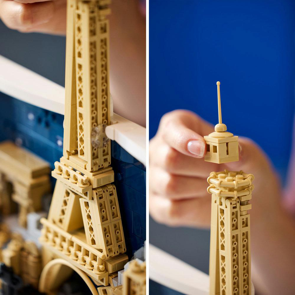 Hände, die einen Lego Eiffelturm zusammensetzen. Eine Hand hält die Turmbasis, die andere den oberen Abschnitt mit Antenne. Blauer Hintergrund.