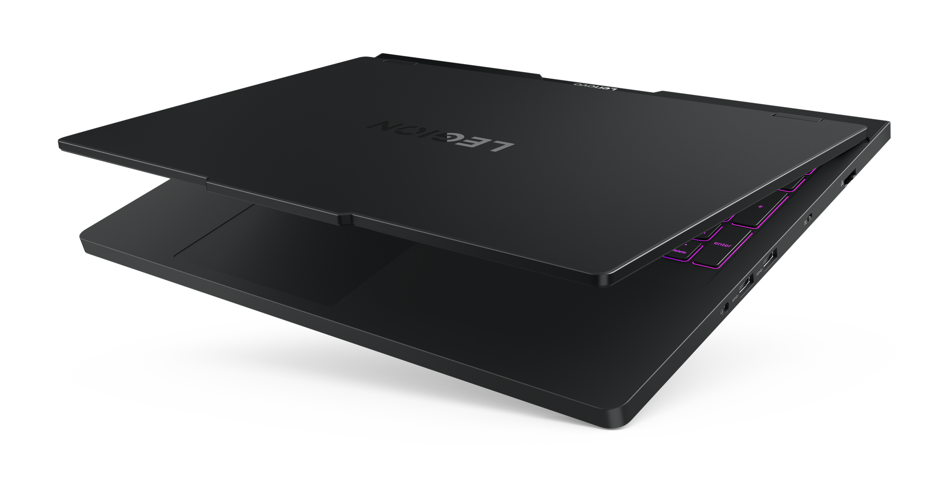 Czarny laptop Lenovo Legion, częściowo otwarty. Klawiatura ma różowe podświetlane klawisze. Tło jest czarne.