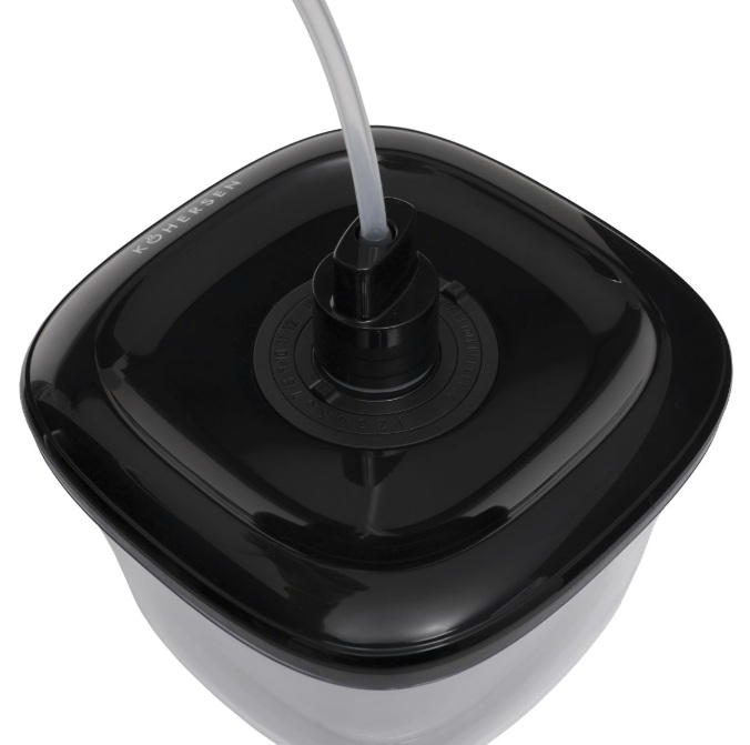 Zbliżenie czarnego plastikowego pojemnika z przezroczystą rurką wychodzącą z góry. Pojemnik ma kwadratowy kształt.