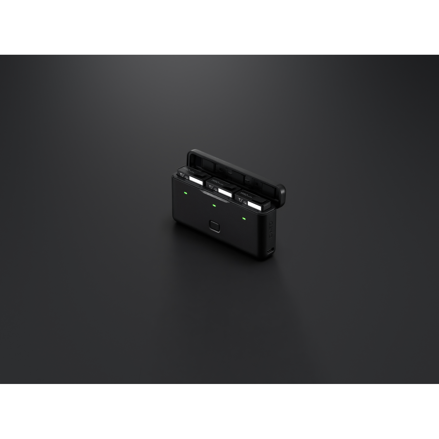 Een zwart oplaadstation met drie sleuven. Twee batterijen zijn geplaatst. De achtergrond is donkergrijs.