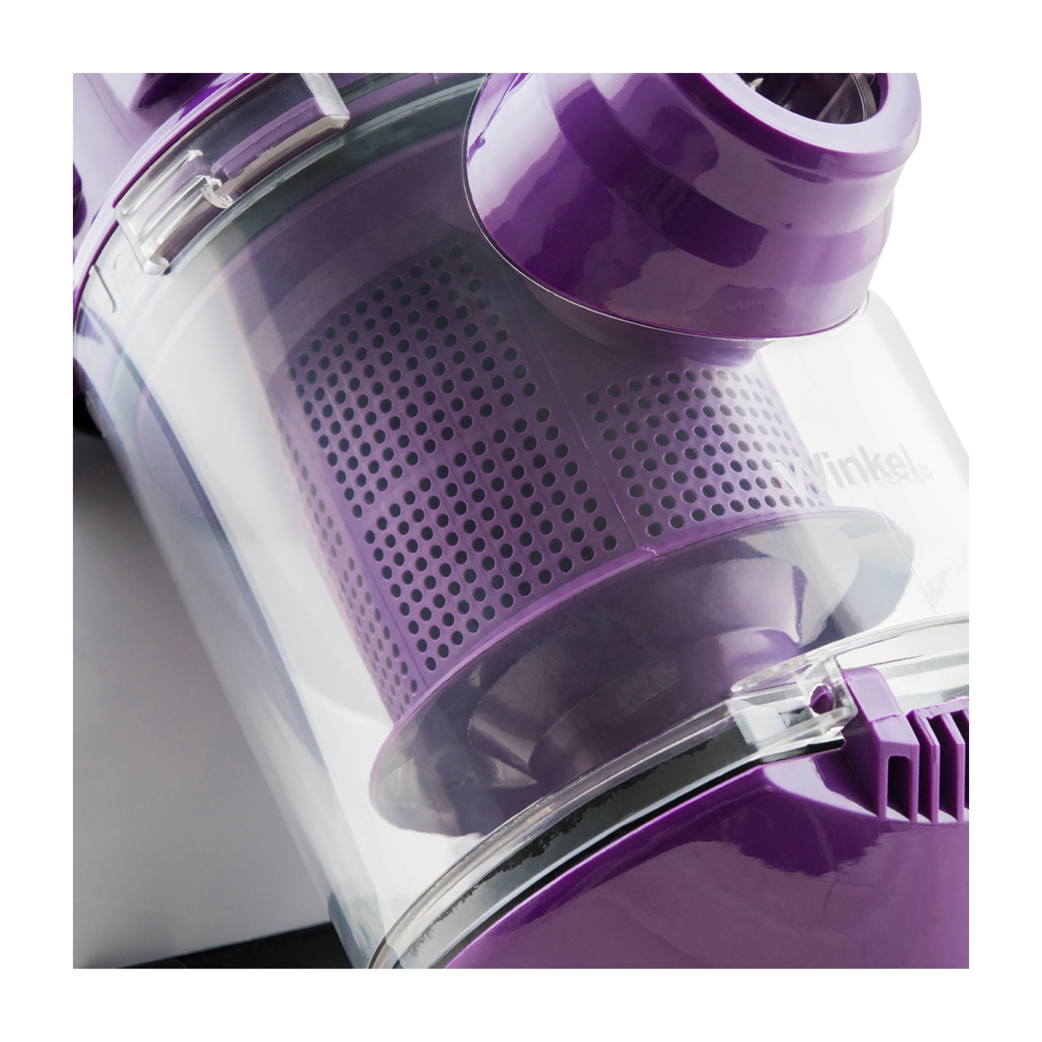 Primo piano di un aspirapolvere viola e trasparente. Il contenitore trasparente rivela un filtro perforato. Il marchio 'Winkel' è visibile.