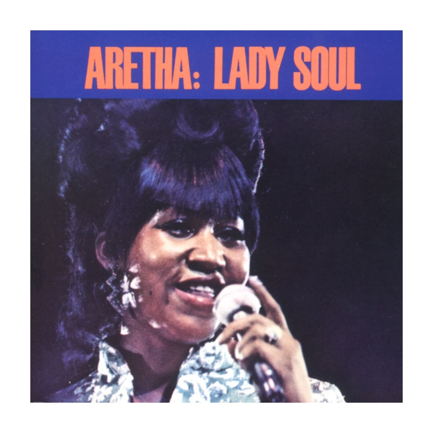Aretha Franklin, con un microfono, sorridente. La copertina dell'album recita 'Aretha: Lady Soul' in arancione su blu.