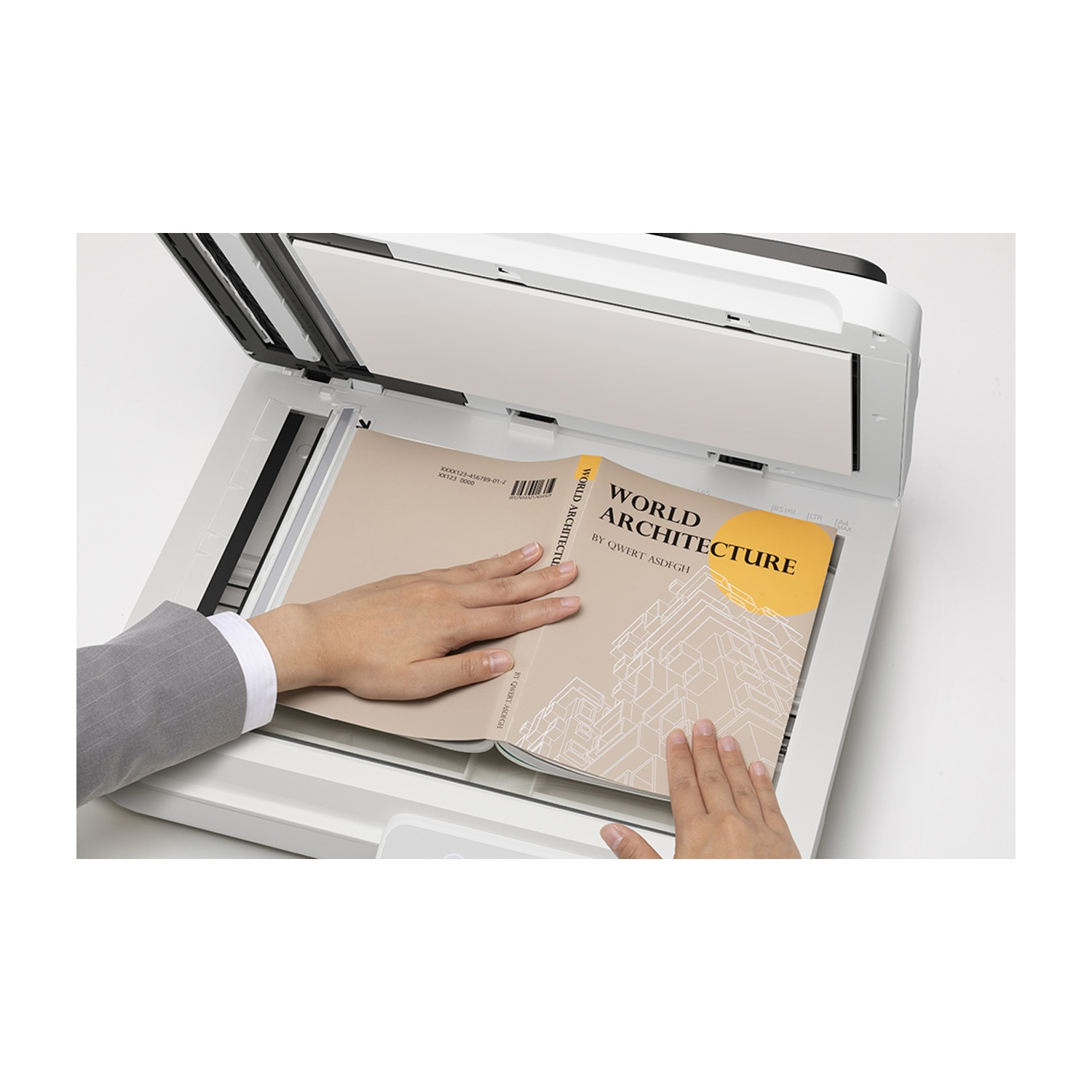 Le mani stanno posizionando un libro intitolato 'World Architecture' su uno scanner. La copertina è beige e gialla. Lo scanner è bianco.