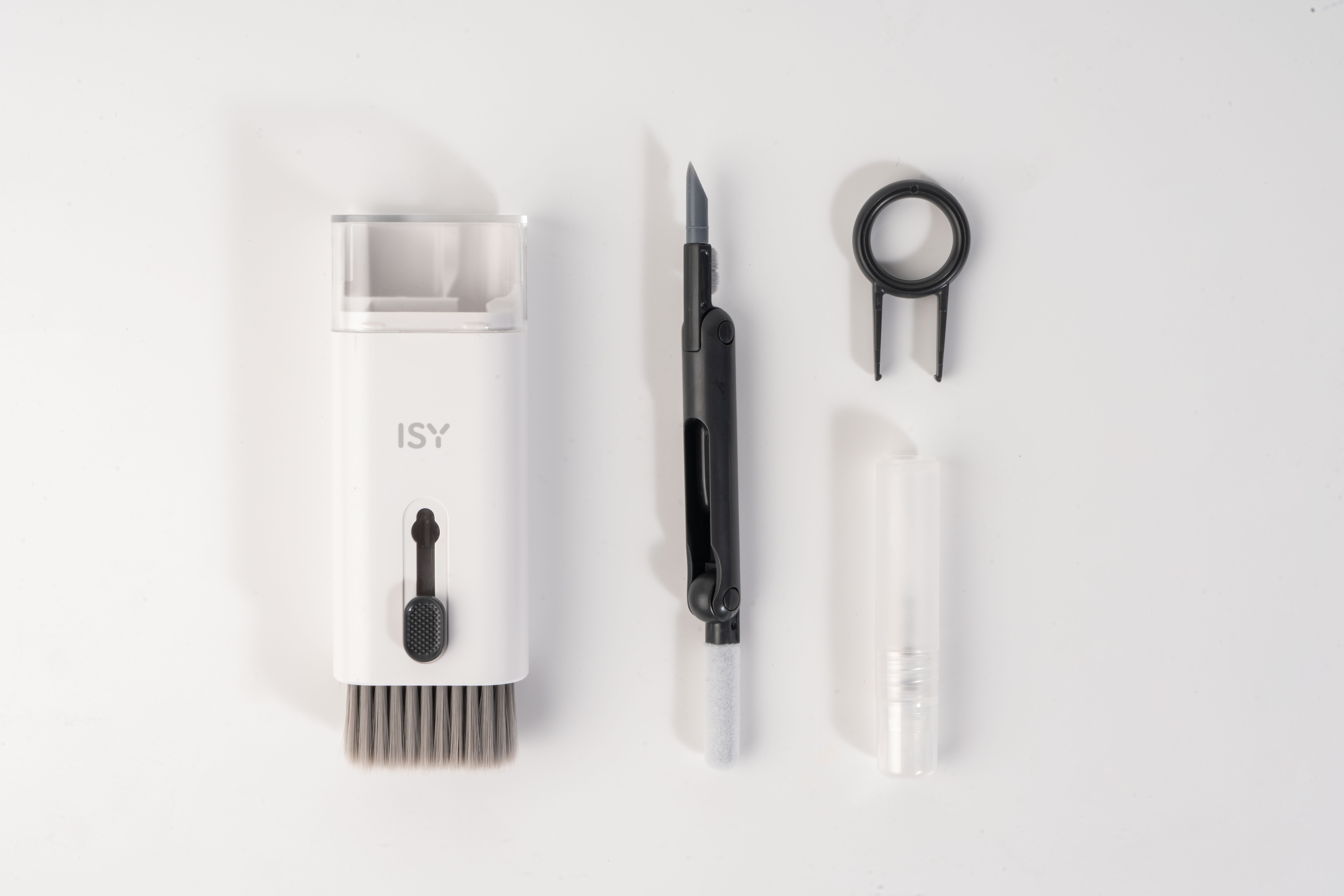 Asortyment narzędzi do czyszczenia na białym tle. Zawiera pędzel, kostkę, pęsetę i mały pojemnik.