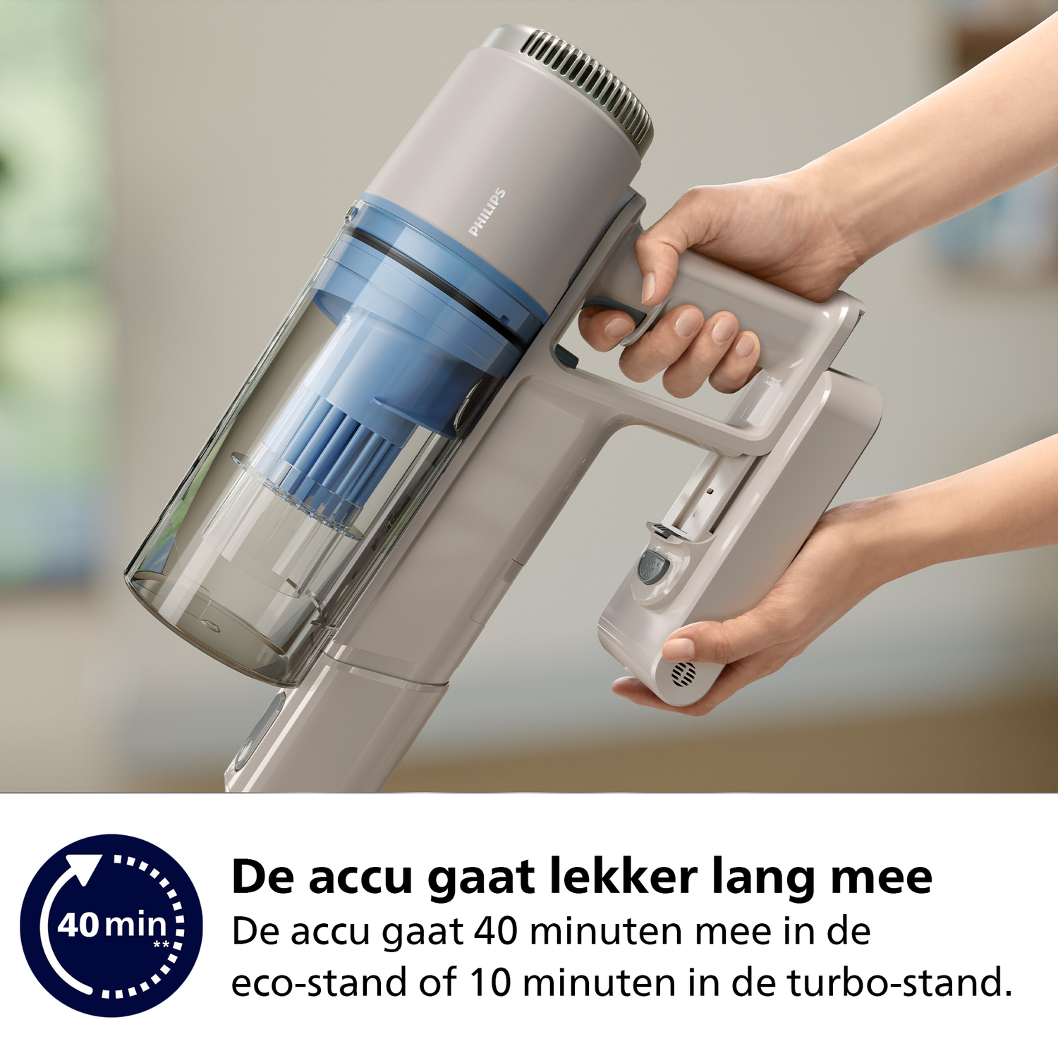 A person holding a gray Philips vacuum cleaner. The vacuum's dust container is blue. Text says the battery lasts 40 minutes.