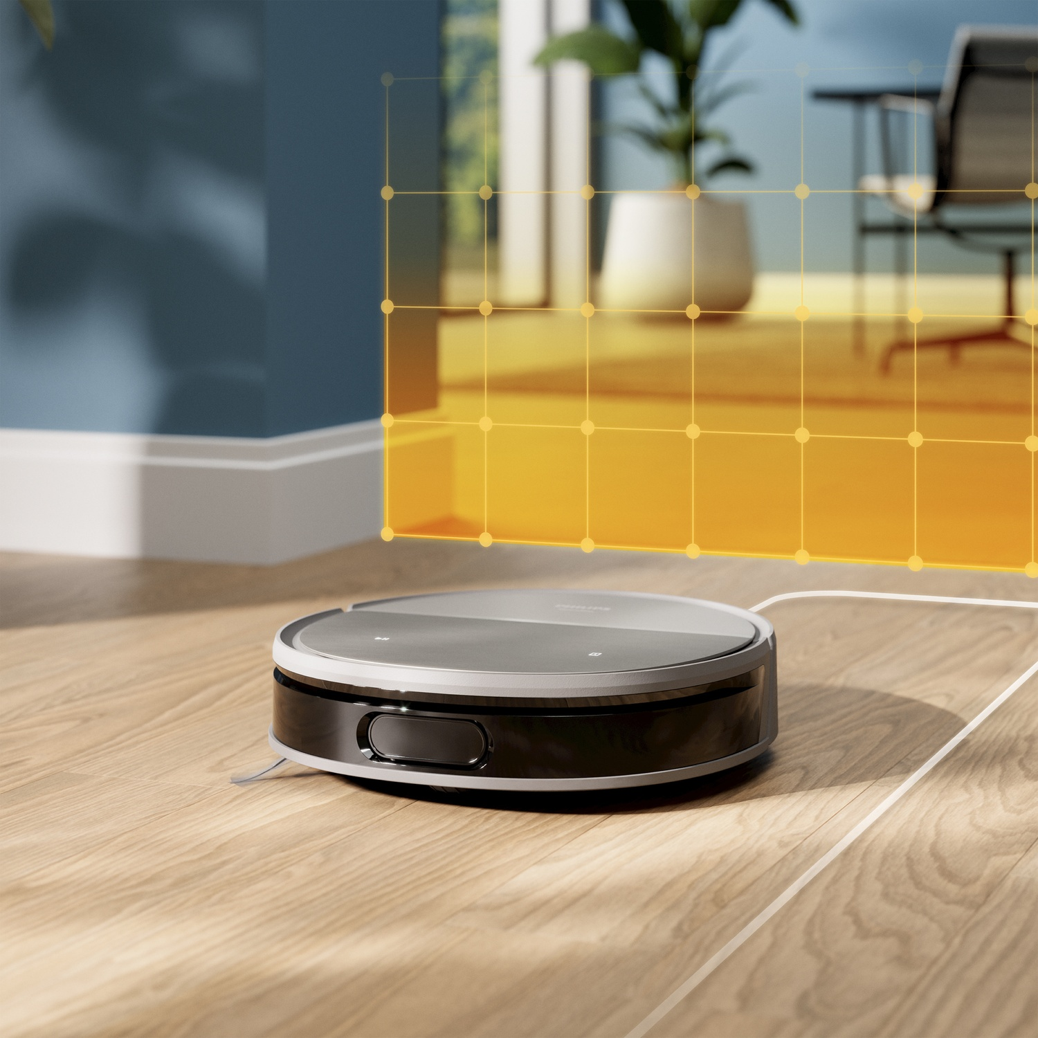 Een robotstofzuiger op houten vloer. Een witte kabel is aangesloten. Op de achtergrond zijn een plant, stoel en oranje raster te zien.