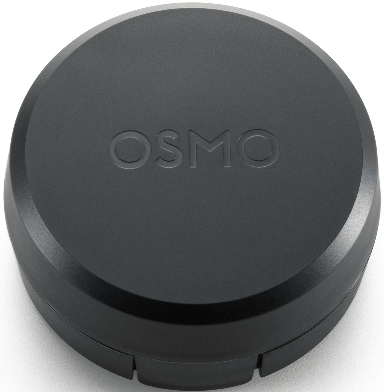 Ein schwarzes, kreisförmiges Osmo-Gerät. Auf der Oberseite befindet sich das geprägte Wort "OSMO". Das Gerät steht auf einer weißen Oberfläche.