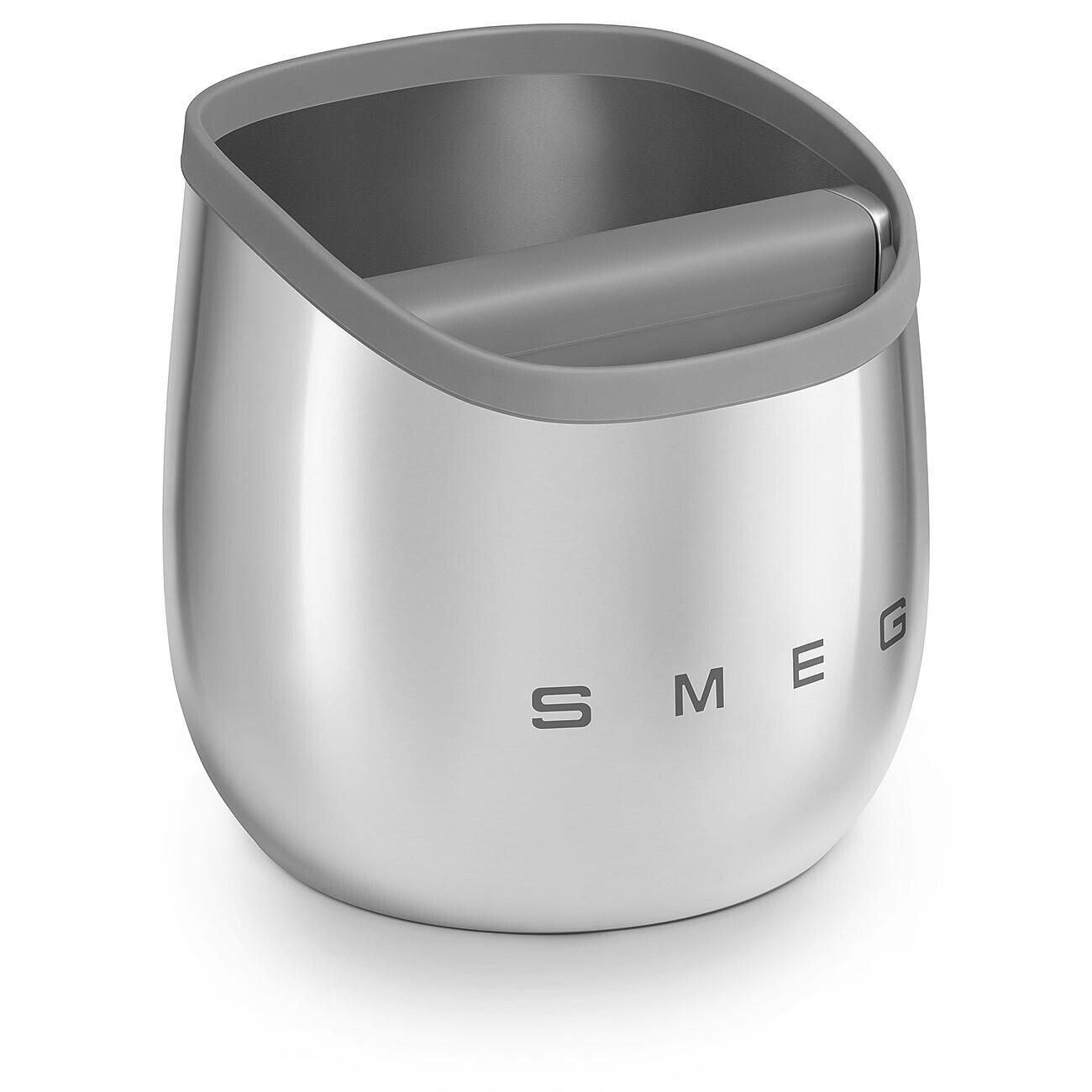 Ein Edelstahl-Smeg-Knock-Box mit grauem Rand. Die Box steht auf einer weißen Oberfläche.