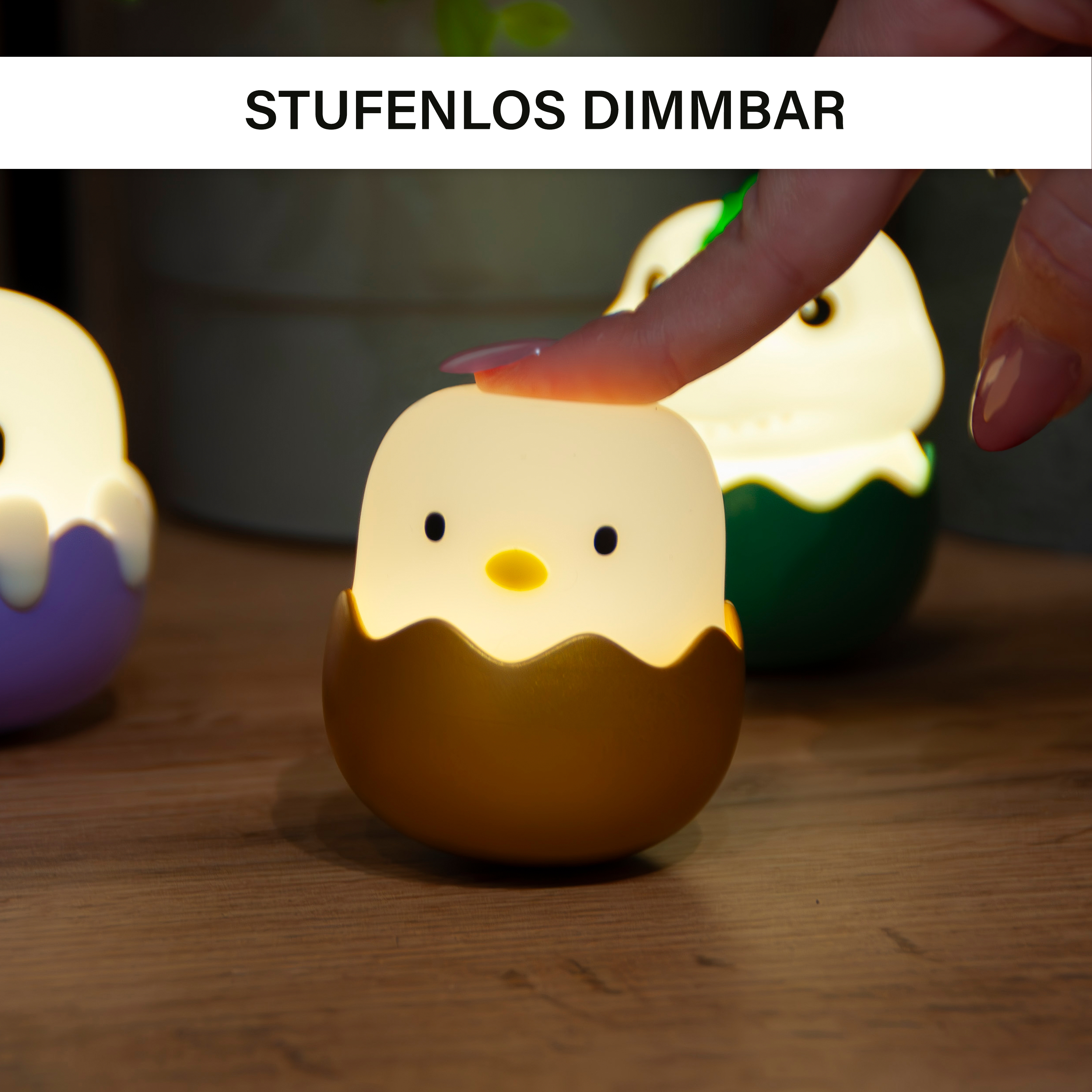 Eine Hand berührt ein Küken-Nachtlicht, das leuchtet. Andere Lichter in Eiform sind sichtbar. Das Wort 'STUFENLOS DIMMBAR' steht darüber.