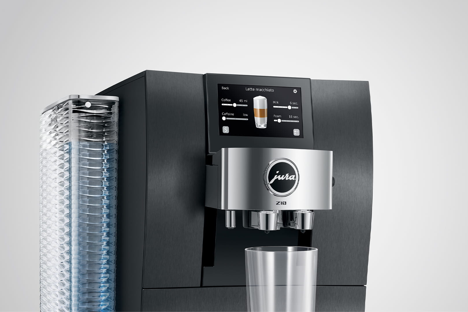 Una macchina da caffè nera Jura Z10 con touchscreen, un bicchiere e un contenitore d'acqua. Un latte macchiato è visualizzato sullo schermo.