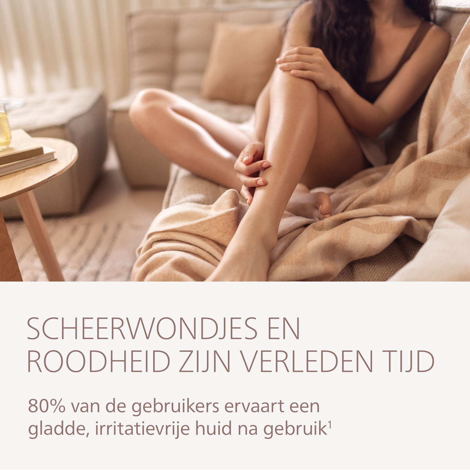 Woman sitting on a sofa, touching her leg. Text: Razor burn and redness are a thing of the past.