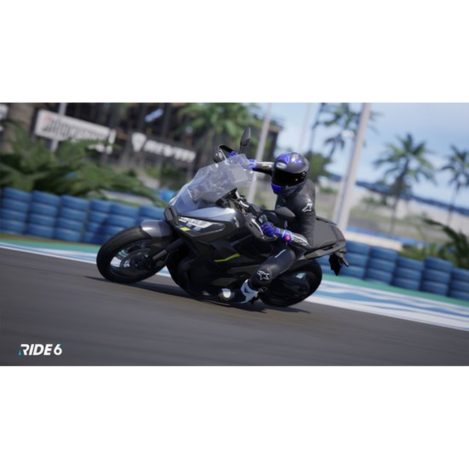 Een motorrijder leunt in een bocht op een racebaan. De motor is zwart en grijs. Palmbomen en een blauwe lucht op de achtergrond.