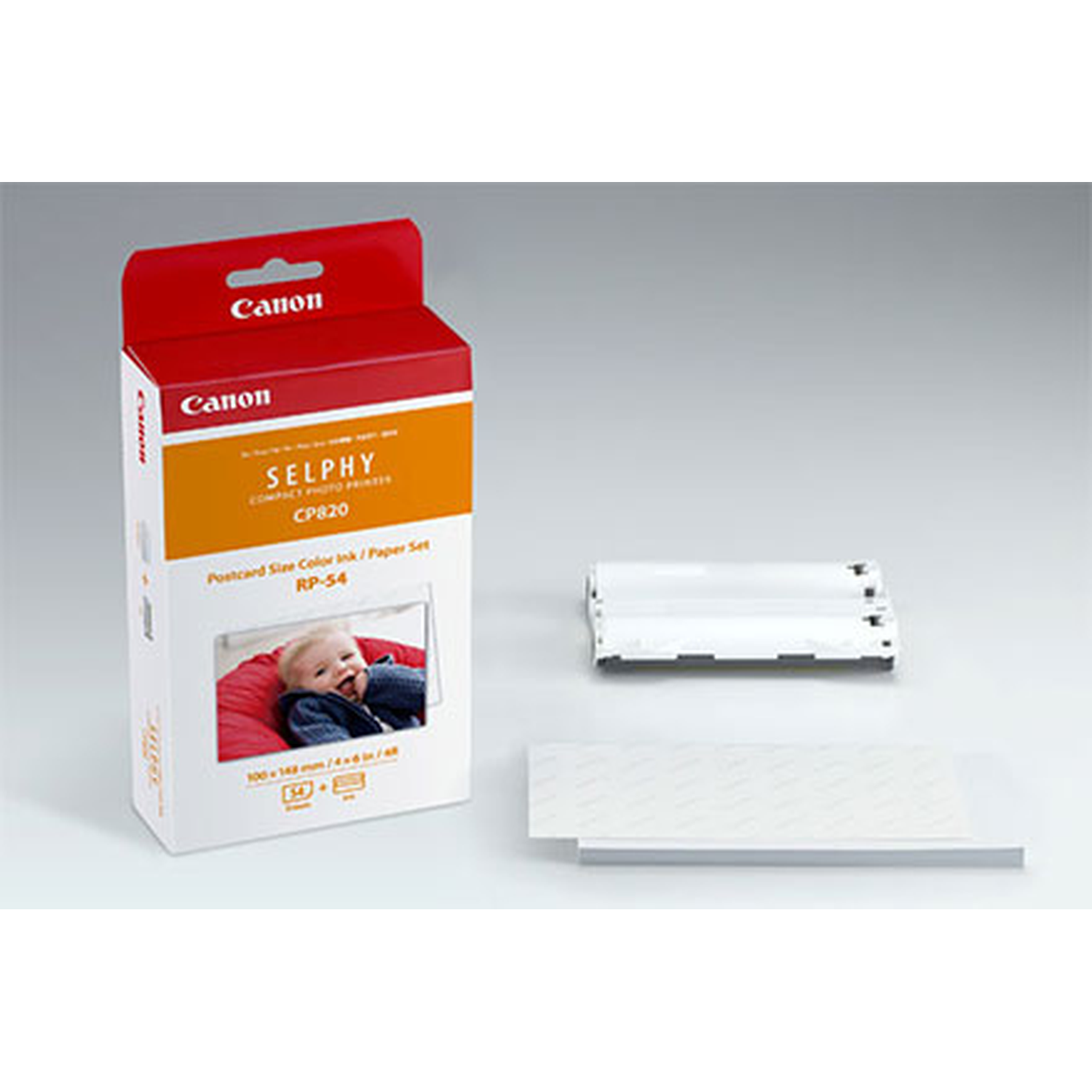 Een Canon Selphy CP820 printerdoos, inktcartridges en papier. De doos toont een baby. De achtergrond is wit.