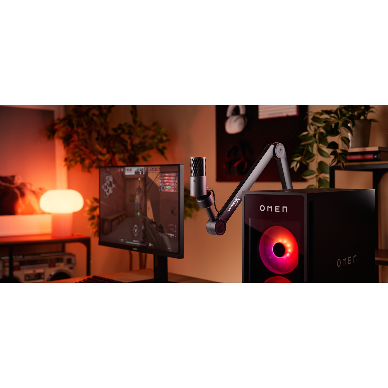 Configuration de jeu avec un moniteur affichant un jeu, un microphone et un PC Omen avec ventilateur lumineux. Arrière-plan avec plantes.