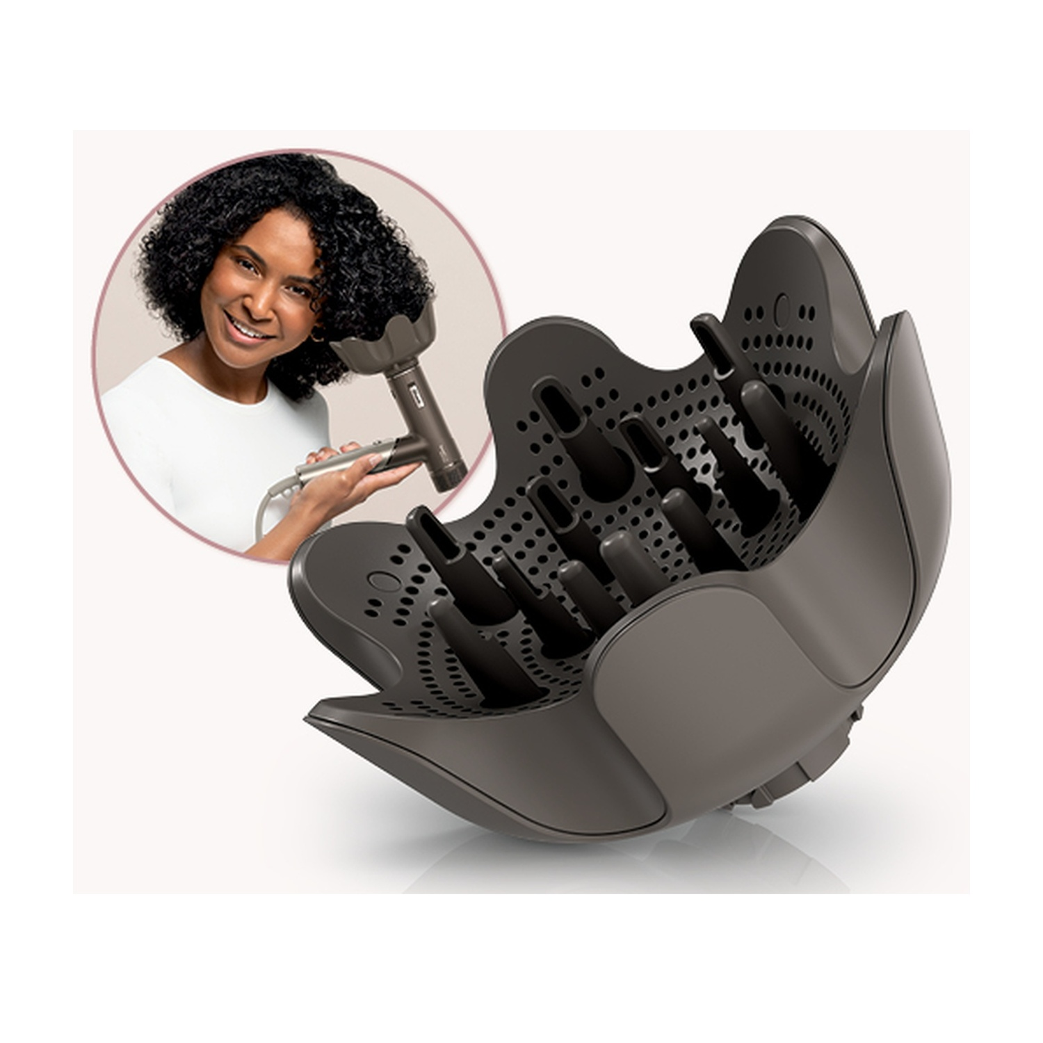Una donna usa un asciugacapelli con un diffusore. Il diffusore è grigio, grande e ha più punte. Un inserto circolare mostra la donna.