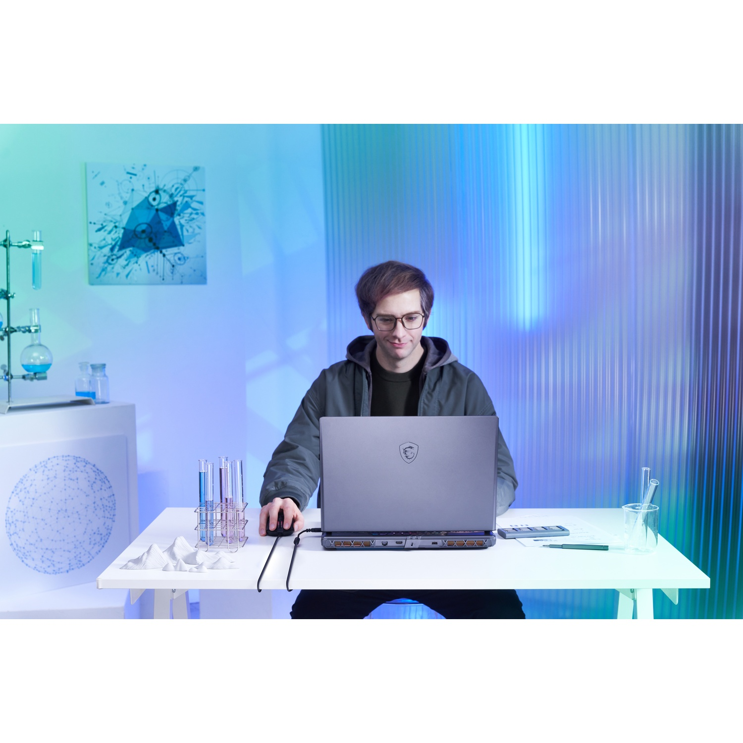 Een man met een bril gebruikt een laptop op een witte tafel. Bekers en wetenschappelijke kunst op de achtergrond. De scène heeft blauwe en groene verlichting.
