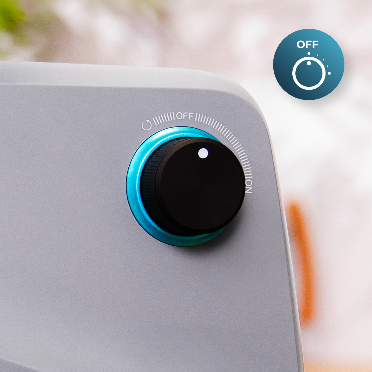 Primer plano de una perilla de control de máquina. Tiene un dial negro, un anillo azul y un indicador de encendido/apagado. El fondo está borroso.