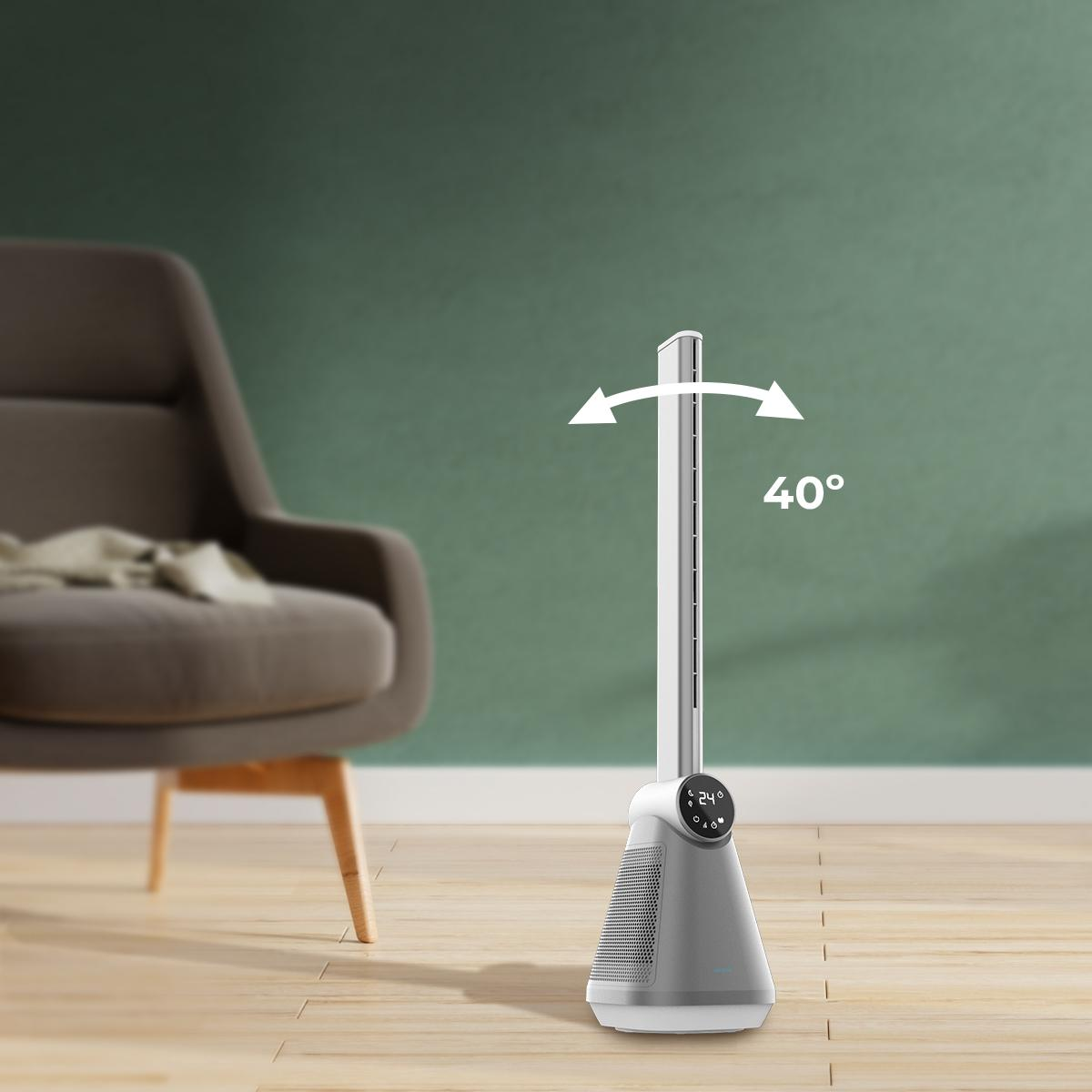 Un ventilador blanco y gris está en el suelo de madera. Hay un sillón detrás. El ventilador tiene flechas que indican una oscilación de 40°.