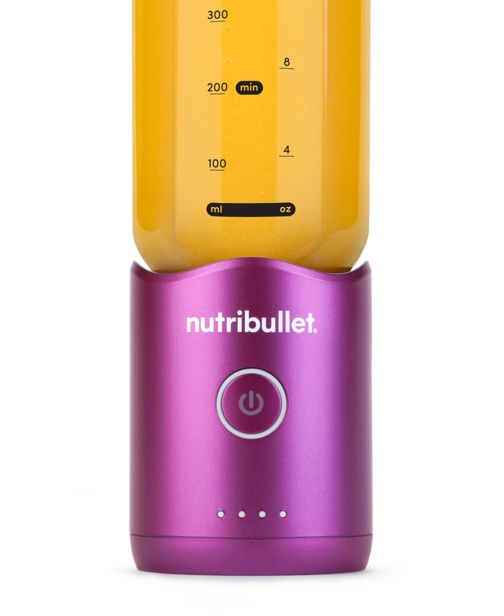 Ein lila Nutribullet-Mixer mit einem Behälter, der mit orangefarbener Flüssigkeit gefüllt ist.
