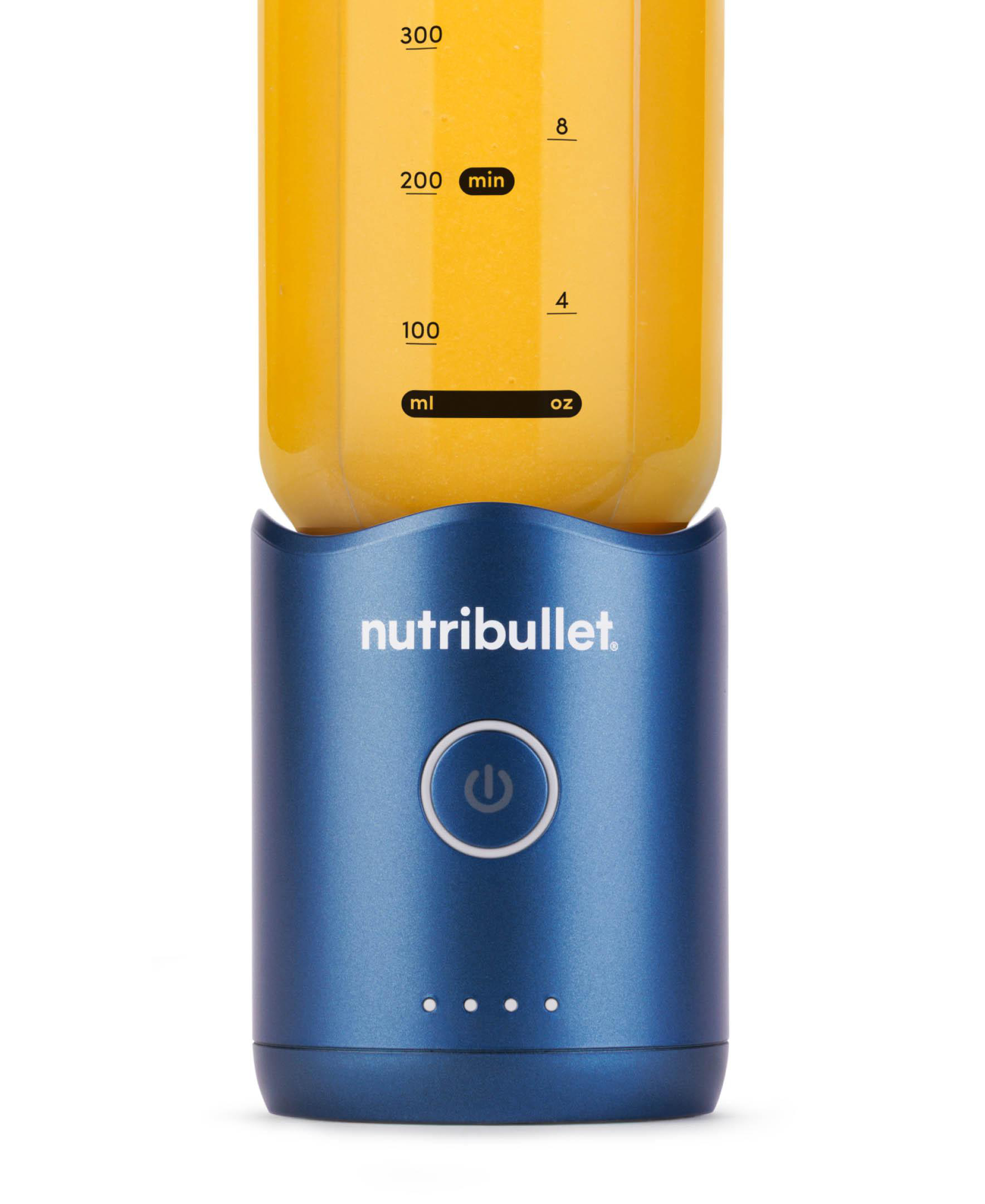 Ein blauer Nutribullet-Mixer mit Saft im Inneren. Er hat einen Einschaltknopf und Volumenmarkierungen.