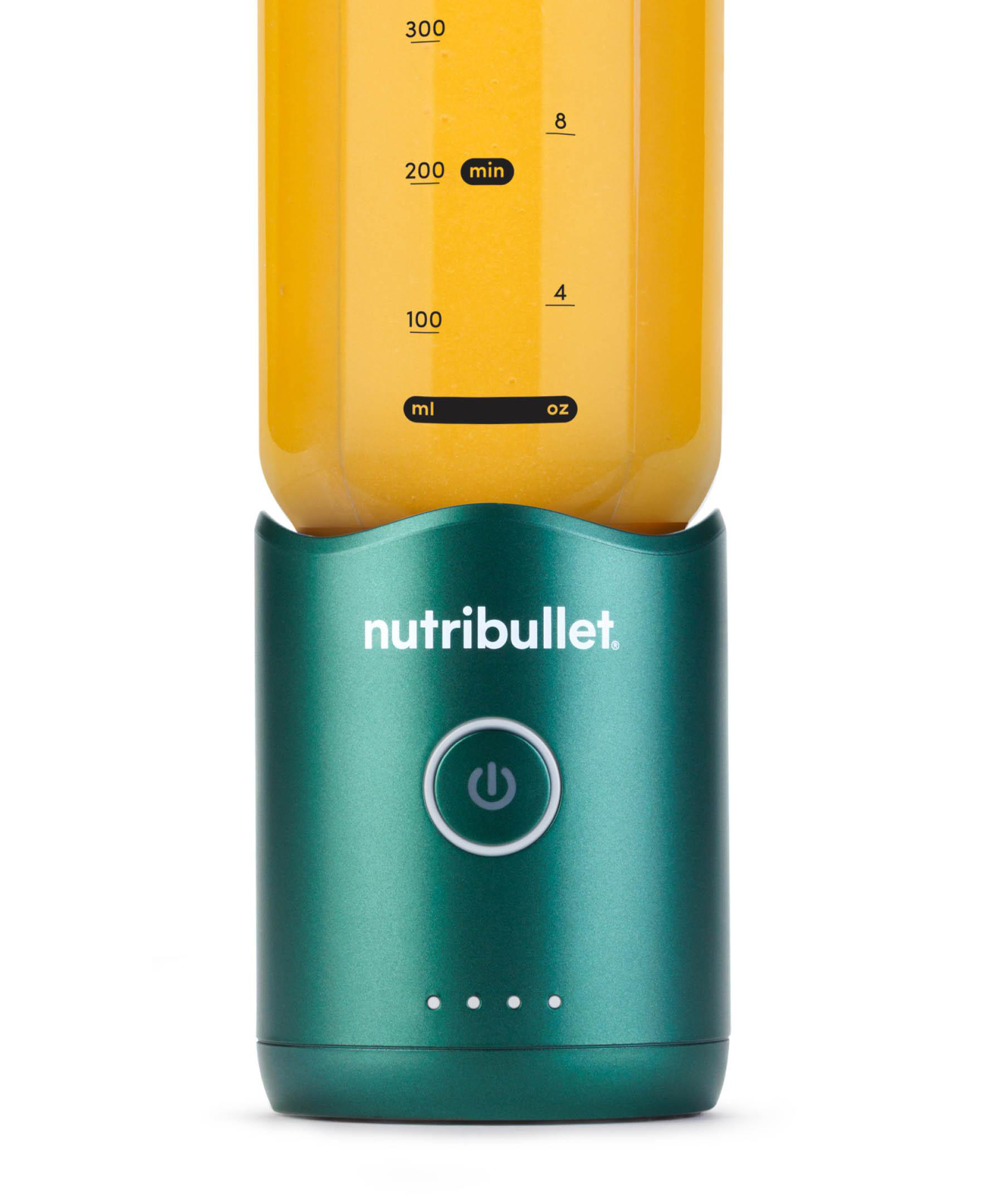 Ein grüner Nutribullet-Mixer mit Saft. Der Mixer hat einen Einschaltknopf und Kontrollleuchten. Der Behälter hat Messungen.