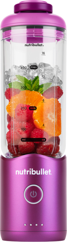 Ein Nutribullet-Mixer mit Früchten und Eis. Rote Himbeeren, Orangenscheiben und Minze sind im transparenten Behälter sichtbar.