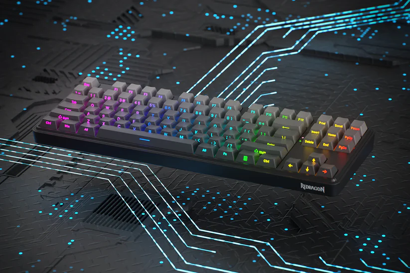 Klawiatura mechaniczna Redragon z podświetlanymi na tęczowo klawiszami na tle płyty obwodu drukowanego z świecącymi liniami.